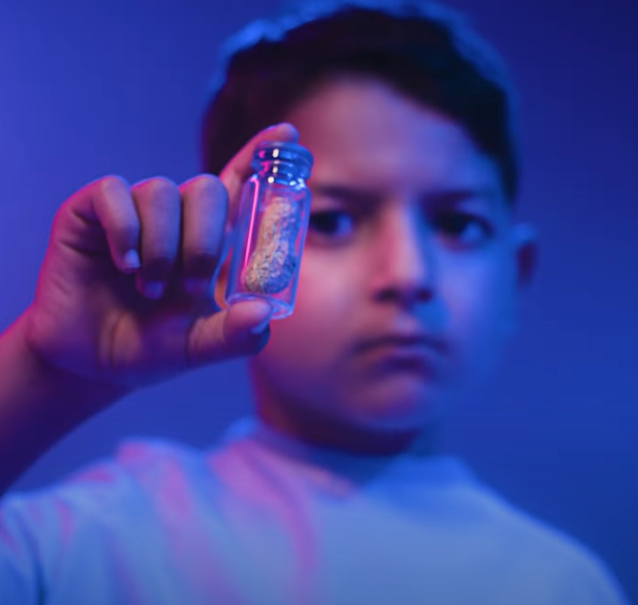 Sickkids patient Simon holding up a vile with a peanut inside